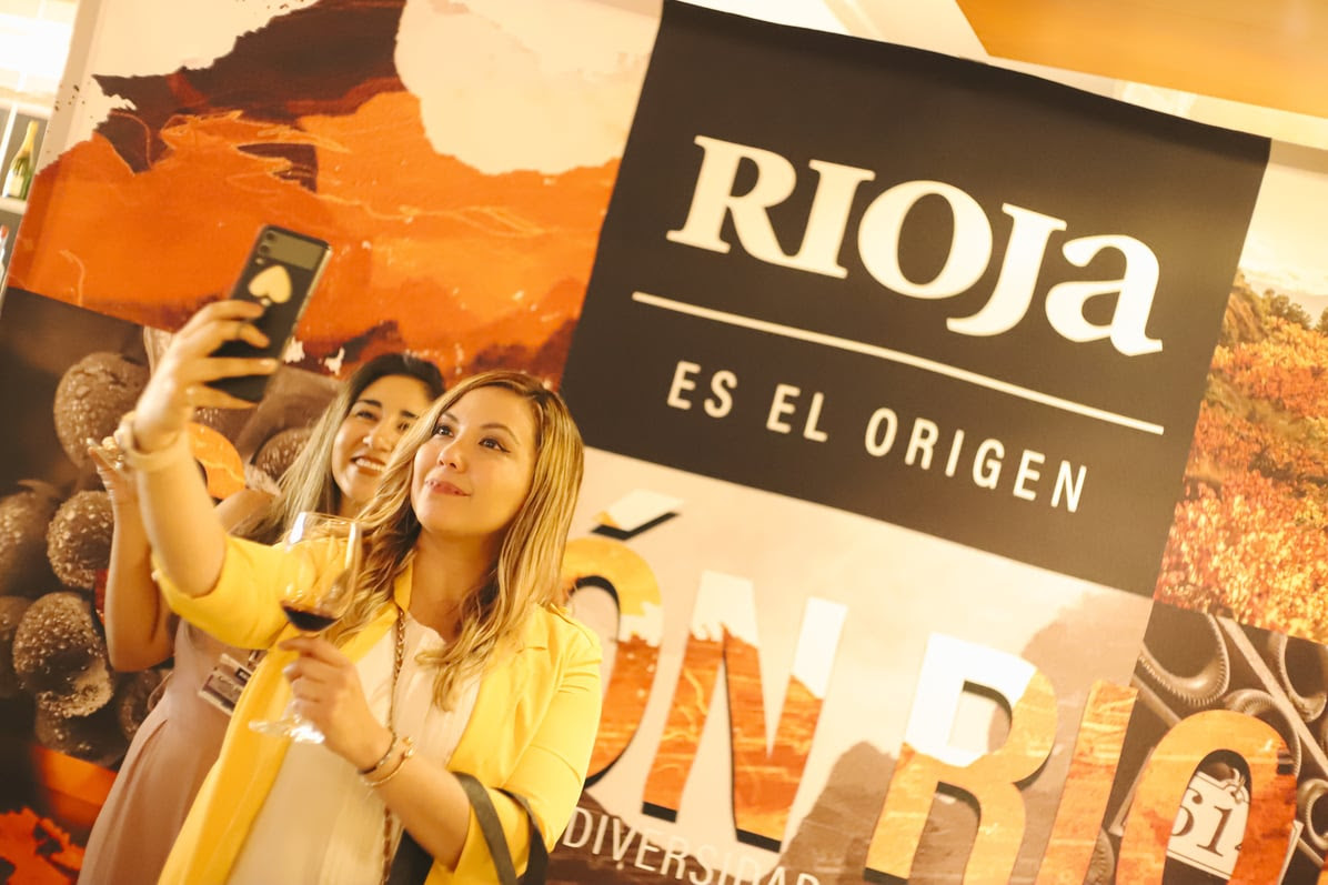 Asistentes al evento haciendose una foto en el fotocall.